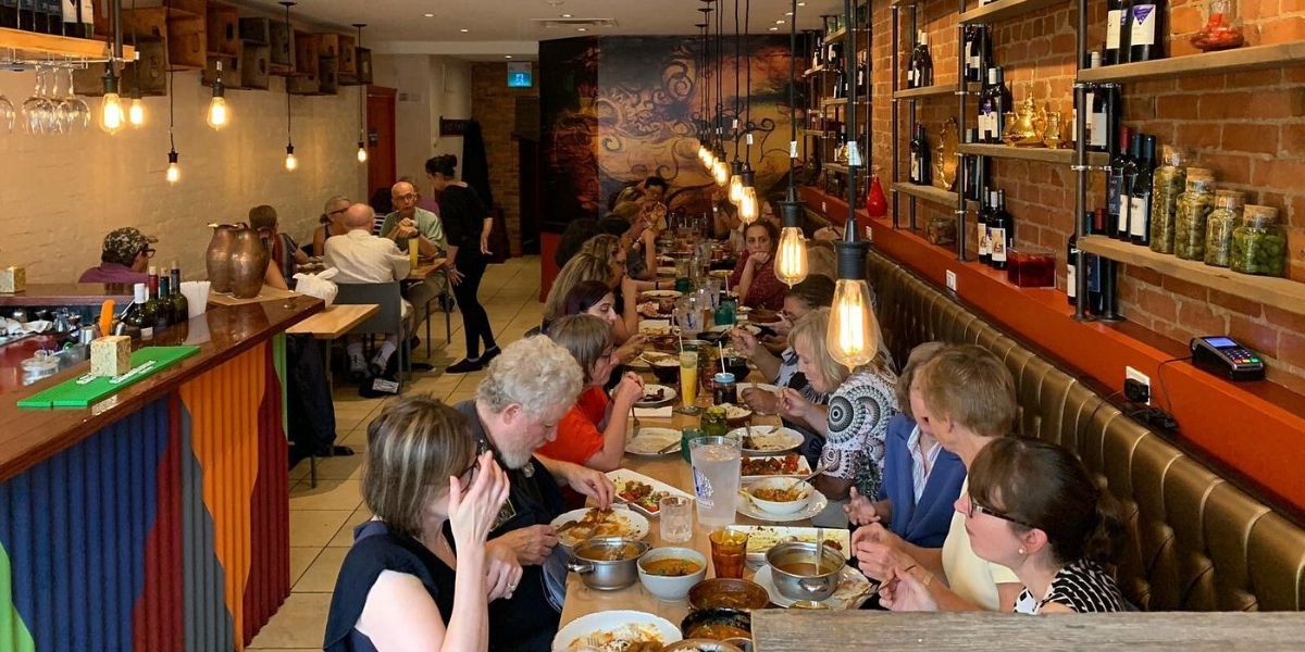 Diverse group of people enjoying a meal at a restaurant.