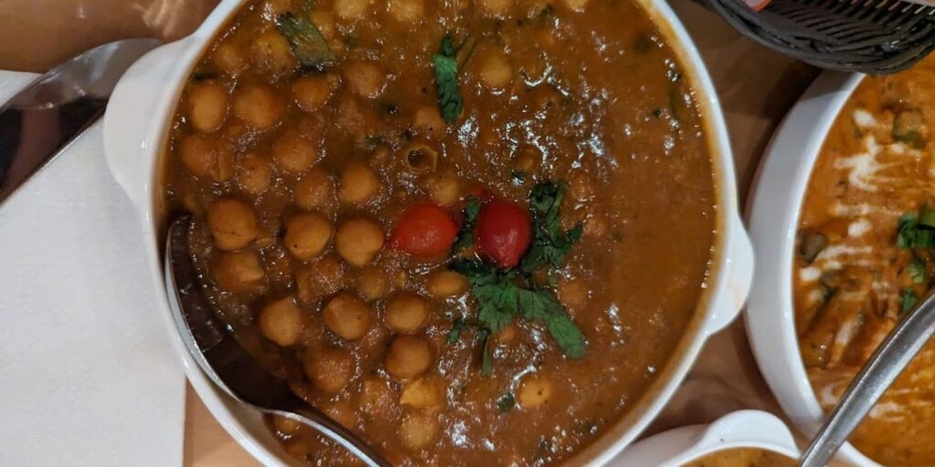 A bowl of chole Bhature, North Indian cuisine with beans and vegetables, a hearty and flavorful street food staple from Punjab.