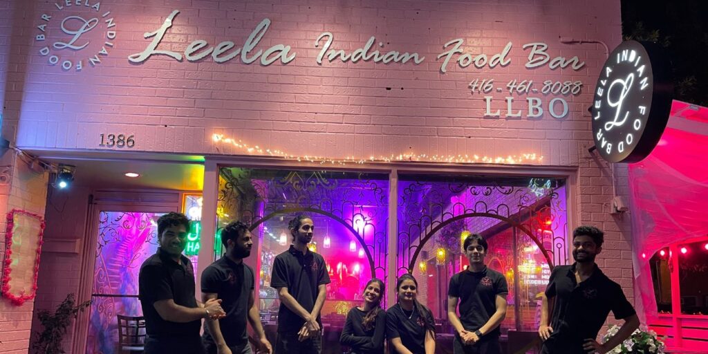 A group of people standing outside Leela Indian Food Bar, the best Indian restaurant in Toronto.