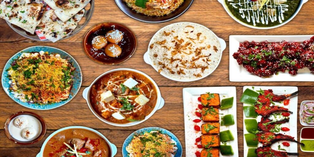 A selection of colorful dishes displayed on a wooden table, including salads, pasta, and grilled vegetables.