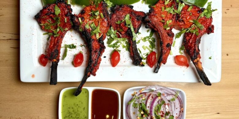A plate with skewers of Tandoori Chicken, vegetables, and flavorful spices.
