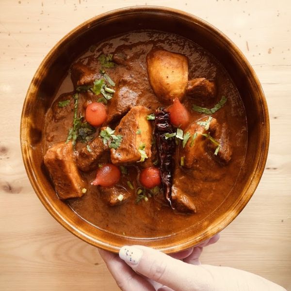 A vibrant bowl of curry featuring tender meat and fresh vegetables, showcasing a blend of spices and flavors.